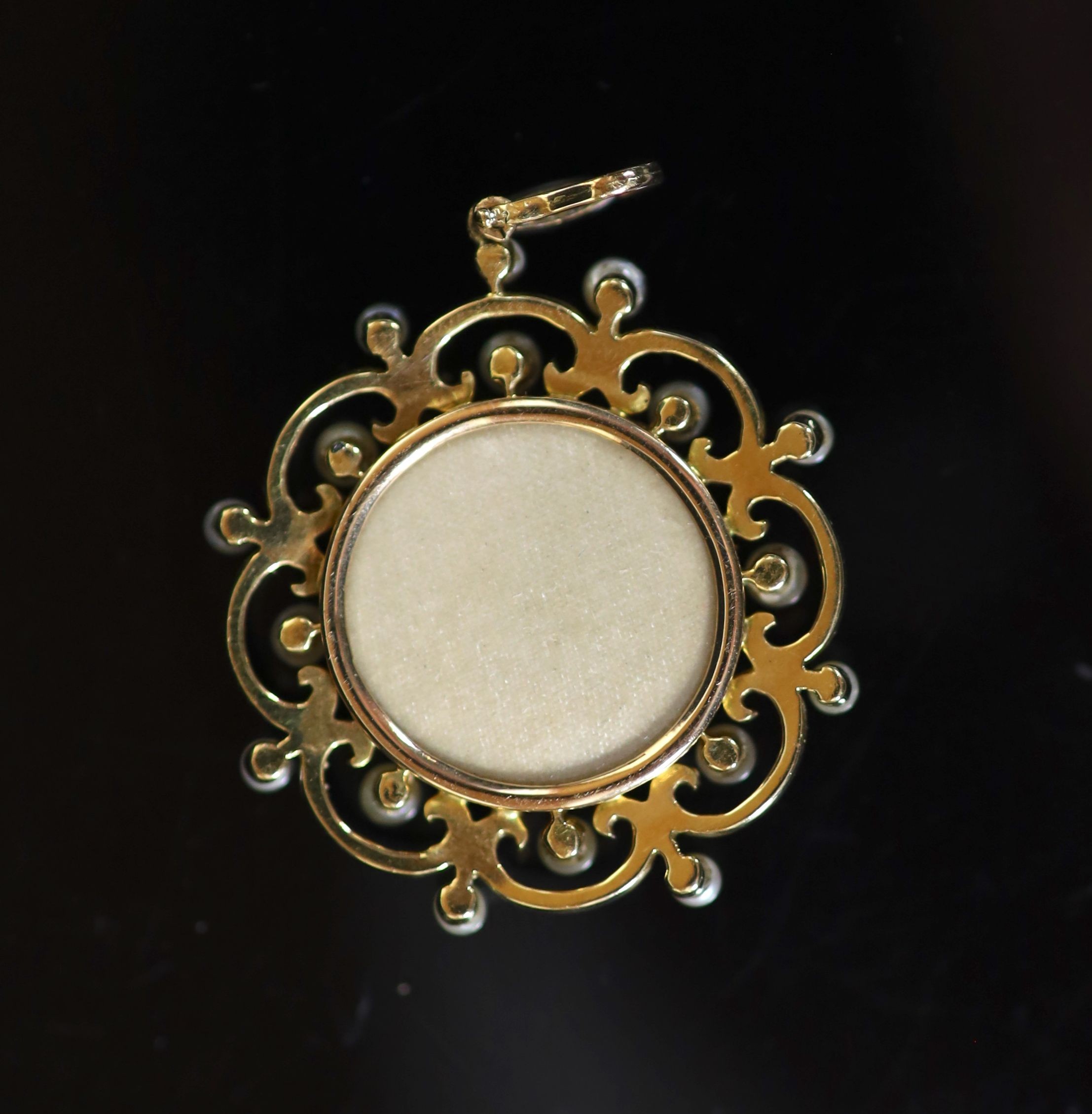 A Belle Epoque gold, green enamel, seed pearl and rose cut diamond set circular pendant